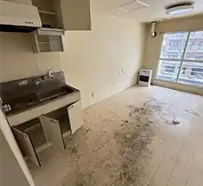 遺品整理・生前整理作業が完了し、全ての家財道具が撤去された札幌市中央区の1K室内。キッチンから居室まで荷物が一つもなくなり、長年の生活の跡が残る床面や壁が露出した、清々しい明け渡し前の状態。