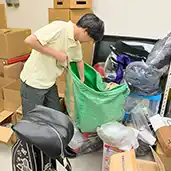 物があふれた部屋から貴重品を探索している様子の写真